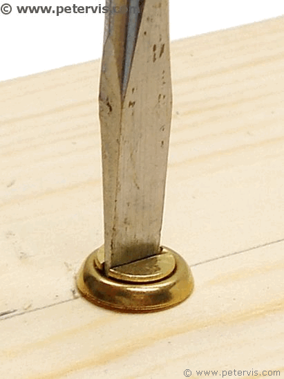 Using a slotted screwdriver.